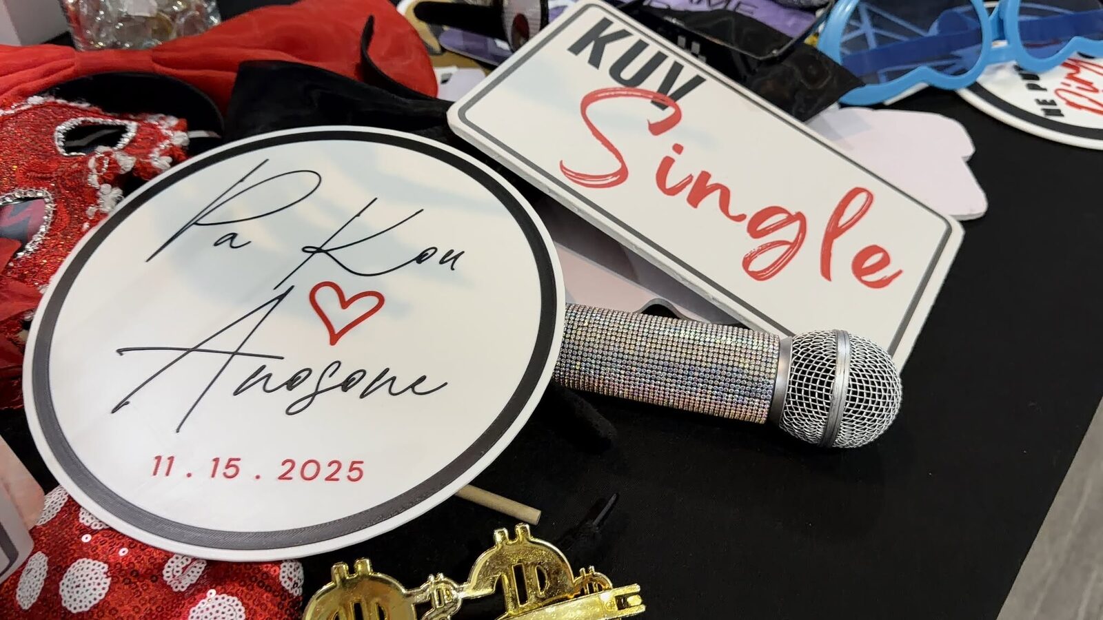 Custom 3D-printed props laid out at a wedding — a round sign with the couple's names and date, and a novelty plate